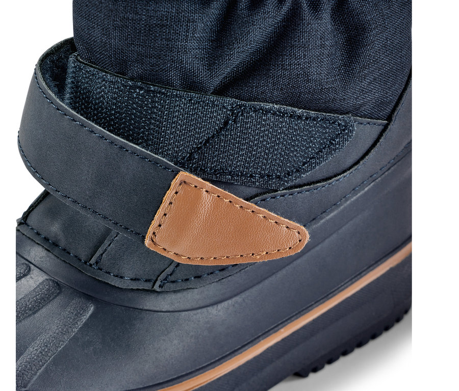 Detailansicht eines Kinder-Allwetterstiefels, blauer Stiefel mit Klettverschluss und braunem Lederdetail.