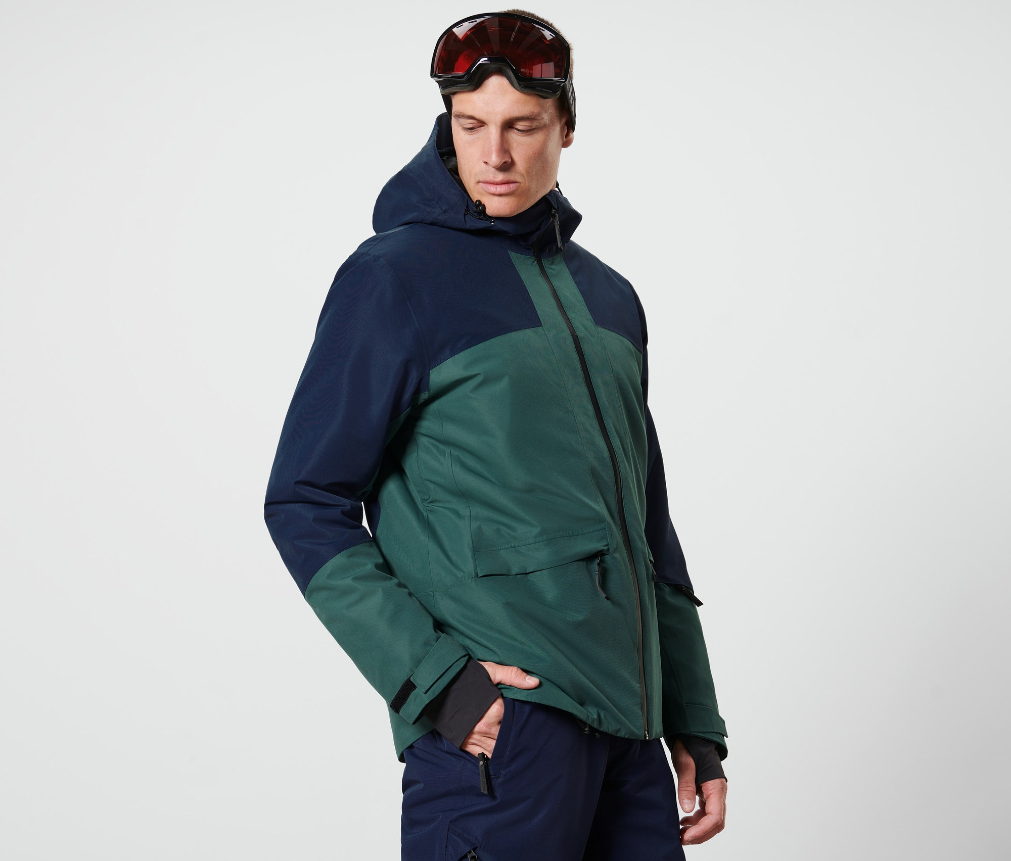 Mann trägt eine blau-grüne Skijacke.