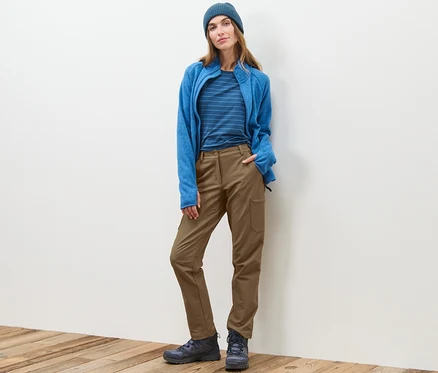 Frau steht und trägt eine beige Cargo-Softshellhose.