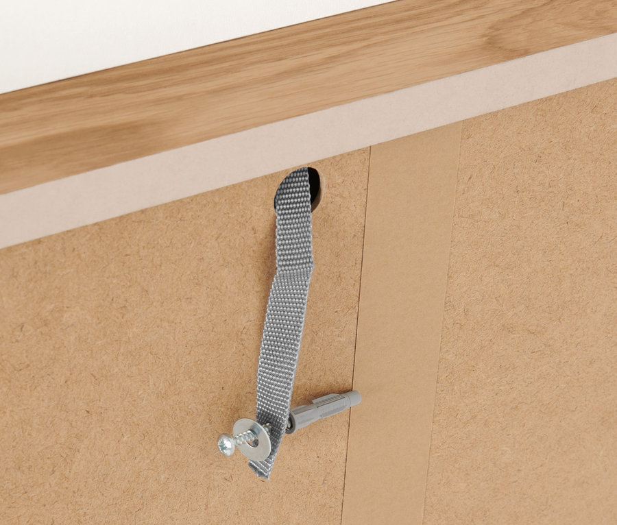 Detail der Befestigung eines Möbelstücks an der Wand mit Schraube, Dübel und Gurt.