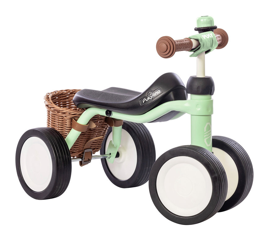 Helles grünes PUKY Laufrad PUKYLINO BUNDLE mit braunem Korb.