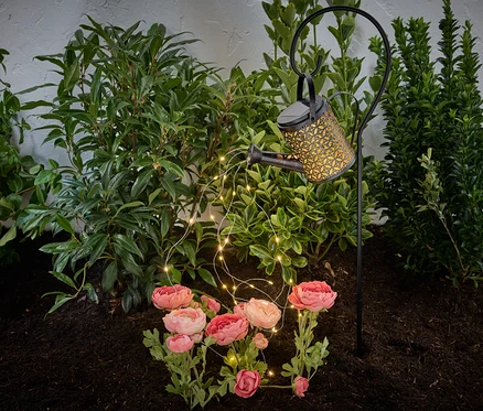 Solarleuchte »Gießkanne« in einem Blumenbeet.