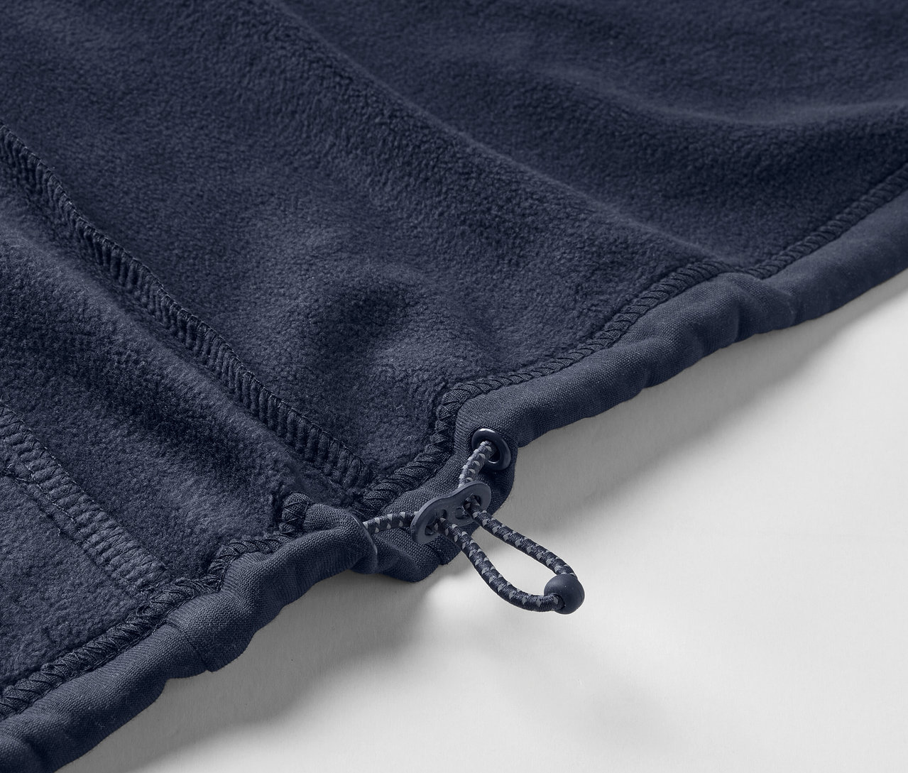 Detailaufnahme einer marineblauen Fleecejacke mit Reißverschluss.