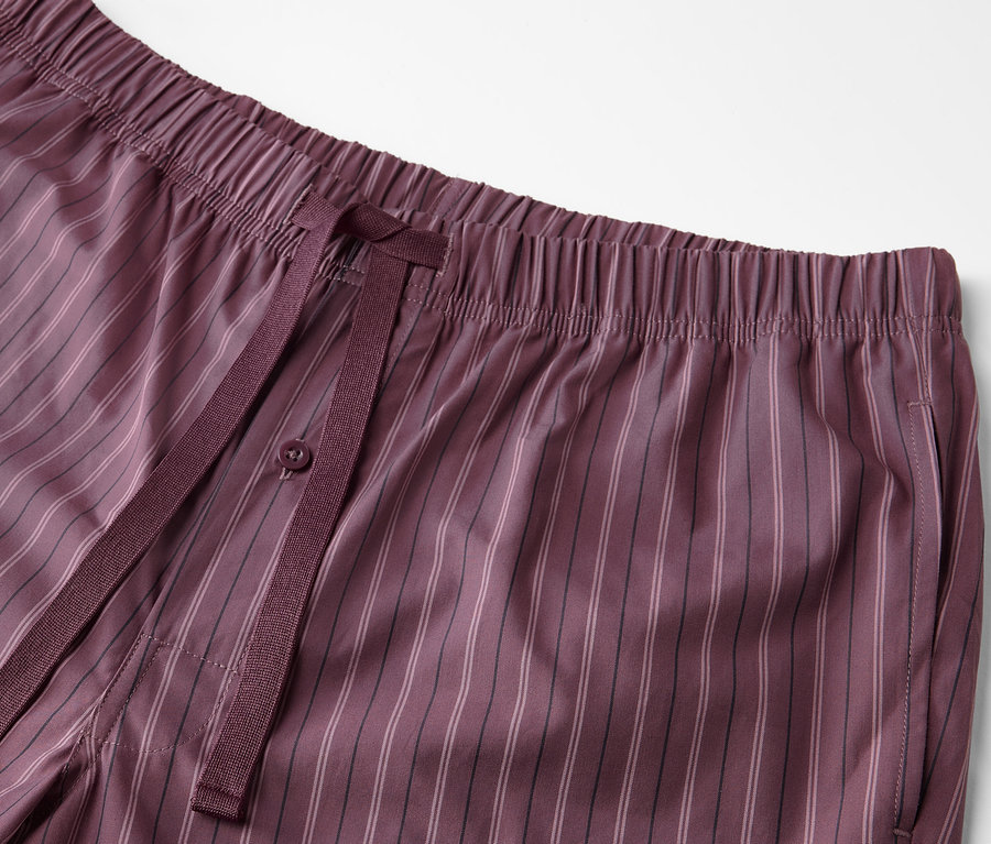Detailaufnahme einer bordeauxroten Pyjamahose mit Webmuster und Kordelzug.