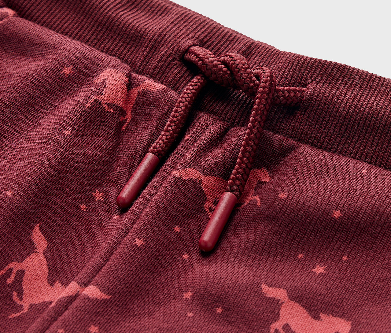 Detail einer Kinder-Jogginghose mit Pferde-Print.
