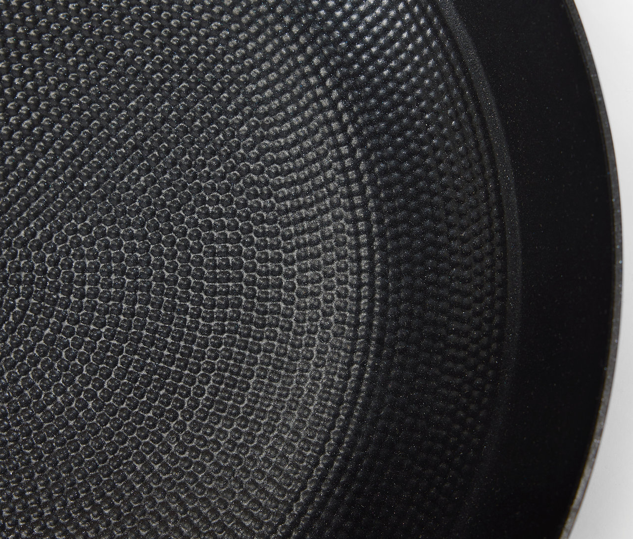 Detailaufnahme der texturierten Oberfläche einer schwarzen Bratpfanne.