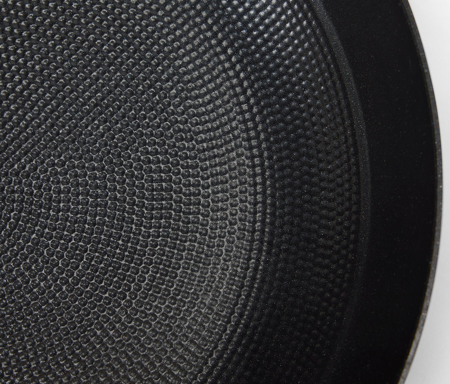 Detailaufnahme der texturierten Oberfläche einer schwarzen Bratpfanne.