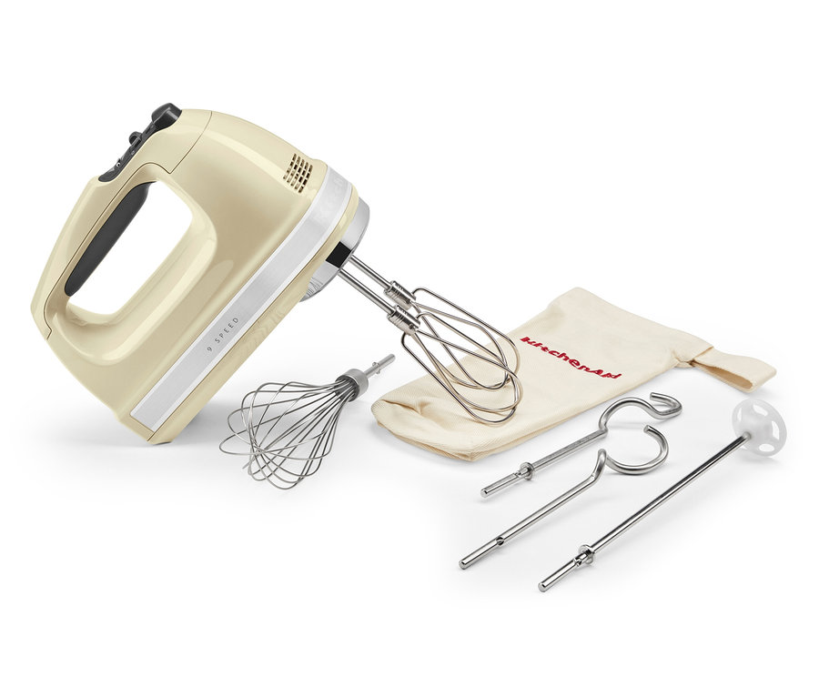 Ein cremefarbener KitchenAid Handmixer mit verschiedenen Aufsätzen.
