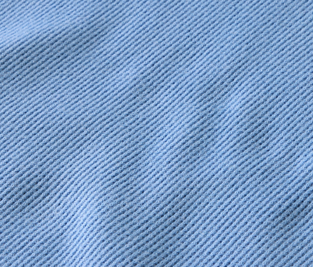 Detailaufnahme eines hellblauen Stoffes mit diagonalen Rippen.