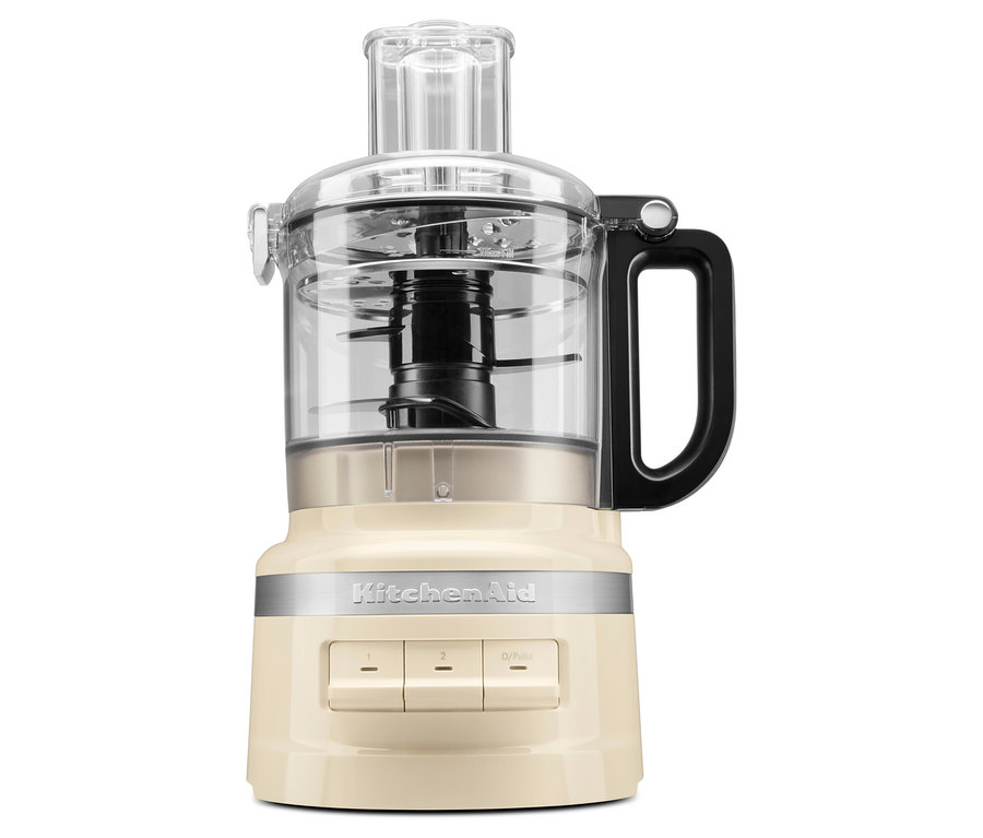 Ein beiger Küchenroboter mit einem transparenten Behälter und einem schwarzen Griff.