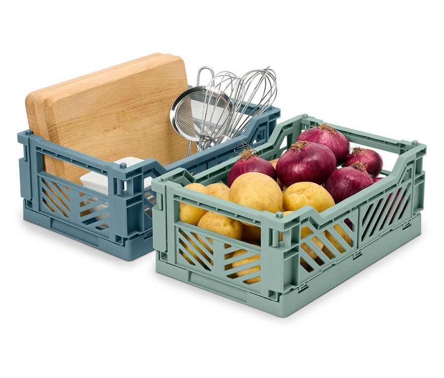 Zwei faltbare Kisten: eine blaue mit einem Schneidebrett und Küchenutensilien, eine grüne mit Kartoffeln und Zwiebeln.