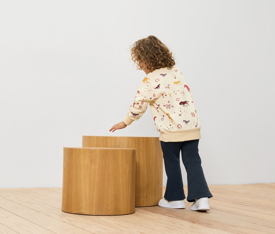 Mädchen schaut auf zwei Holzhocker