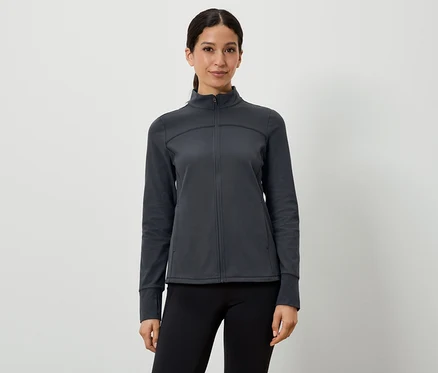 Frau trägt eine dunkelgraue Sportjacke und schwarze Leggings.