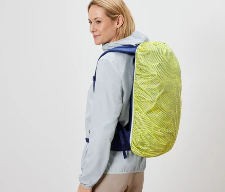 Frau trägt Rucksack mit Rucksack-Regenschutzhülle.