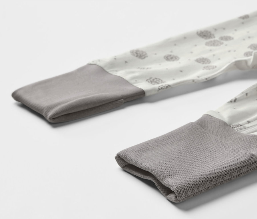 Detailansicht eines 3er-Sets Baby-Schlafanzüge mit grauen Bündchen und Löwenzahnmuster.