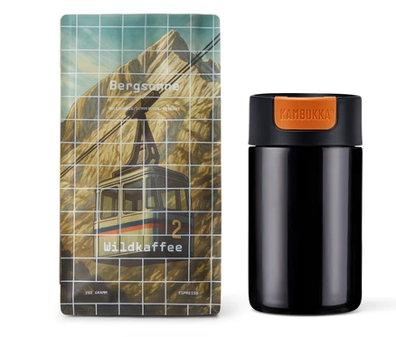 Ein Kaffee-Geschenkset „Höhenluft“ mit 350 g Espresso Ganze Bohne und einem Kambukka Becher steht auf einem weißen Untergrund.