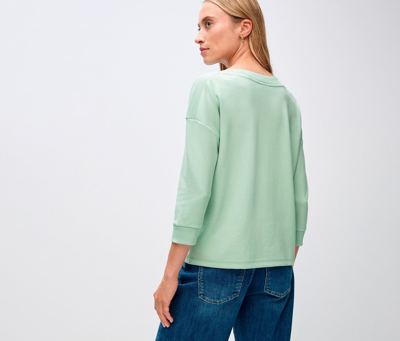 Frau trägt ein salbeigrünes Street One T-Shirt mit Rippdetail.