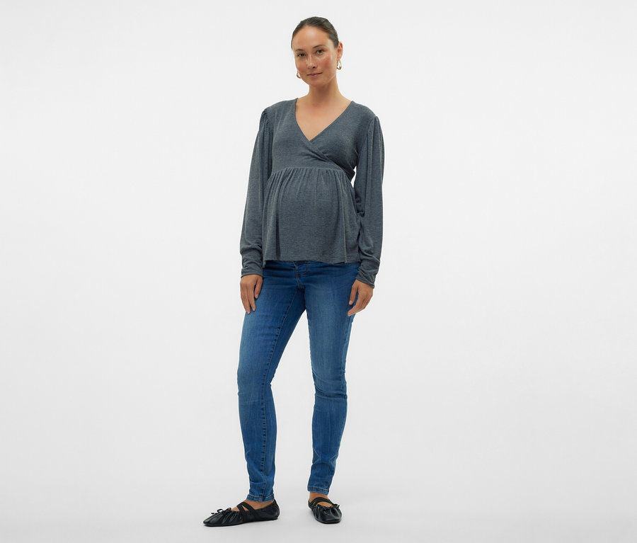 Frau in grauer Wickelbluse und MAMALICIOUS Skinnyjeans »MLMILA«, posiert vor weißem Hintergrund.