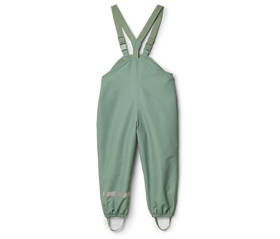 Eine grüne Regenhose mit Trägern liegt auf einem weißen Hintergrund.