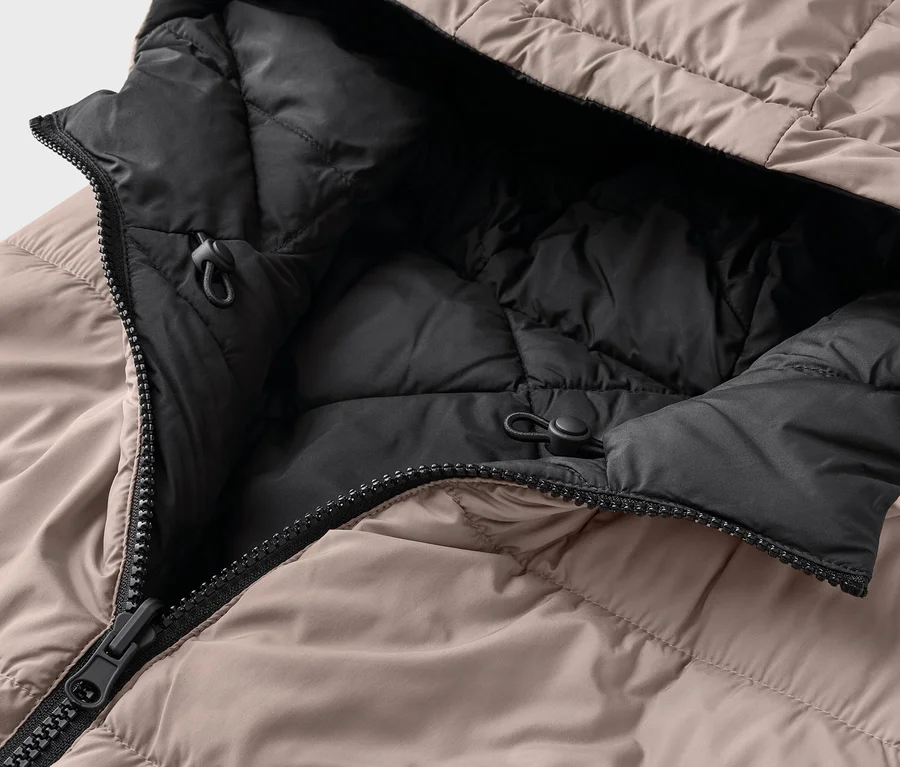 Nahaufnahme einer geöffneten, beigen Daunenjacke mit schwarzem Innenfutter und Kapuze.