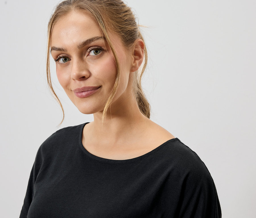 Porträt einer Frau mit blonden Haaren, die ein schwarzes T-Shirt trägt.