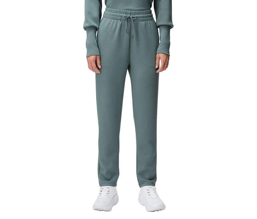 Person trägt eine grüne Jogginghose und weiße Turnschuhe.