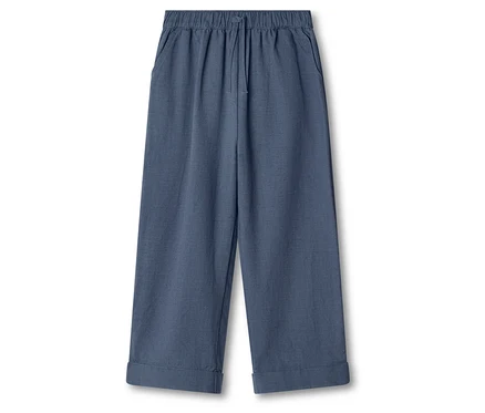 Eine blaue, weite Hose mit Gummizug und Kordel ist auf weißem Grund zu sehen.