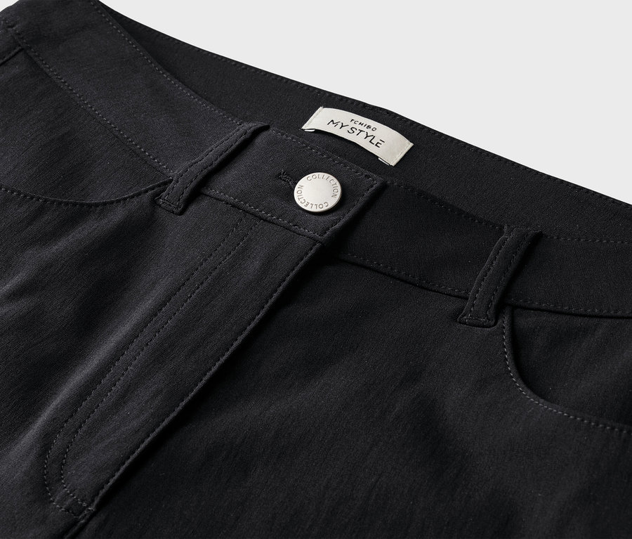 Nahaufnahme einer schwarzen Hose mit Knopf und Taschen.