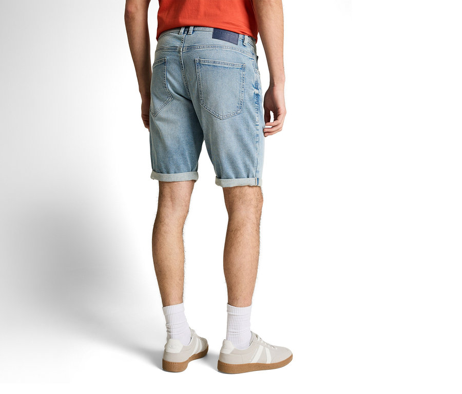 Mann von hinten mit Tom Tailor TTJOSH REGULAR SLIM Jeansshorts in Light Stone Blue Denim, weißen Socken und Turnschuhen.