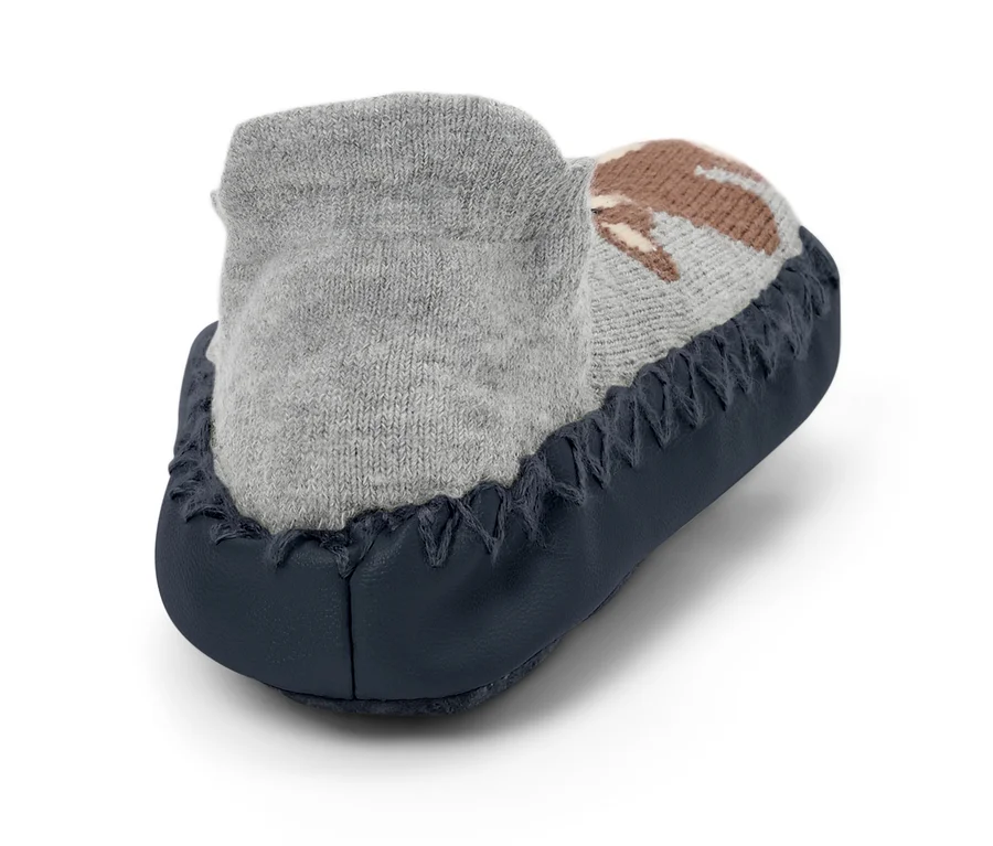 Detailaufnahme eines grauen Babyschuhs mit braunem Muster und dunkelblauer Sohle.