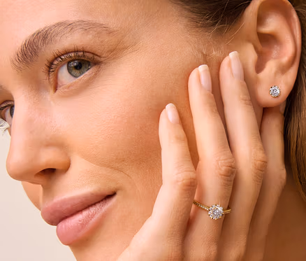 Frau mit 585 Gold Ring Diamanten am Finger und 585 Gold Ohrstecker Diamanten im Ohr.