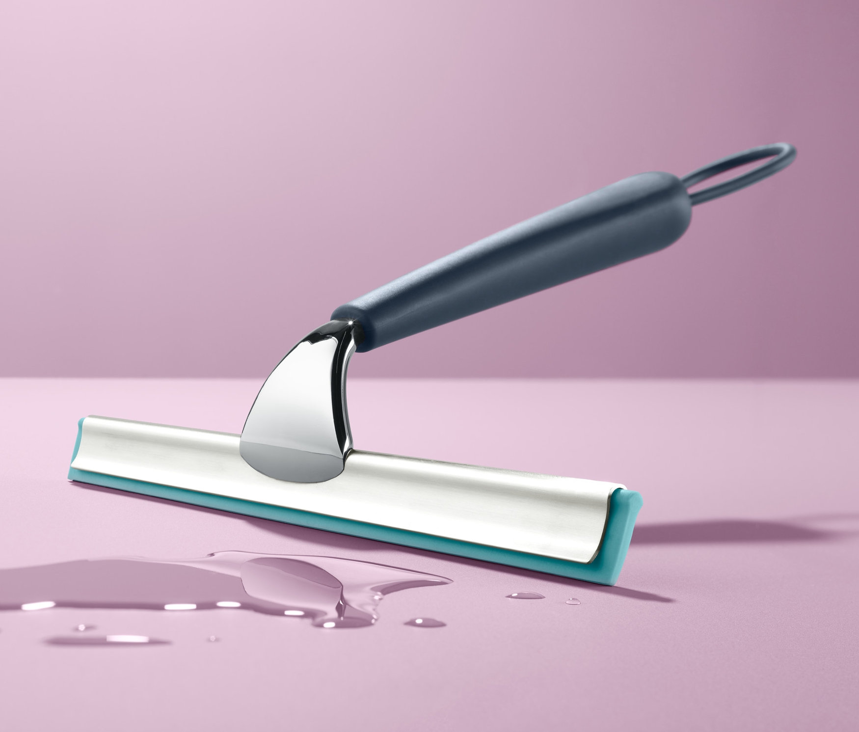 Ein Badwischer liegt auf einer lila Oberfläche neben einer Wasserpfütze.