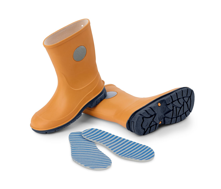 Gelbe Gummistiefel und Einlegesohlen liegen auf einem weißen Hintergrund.