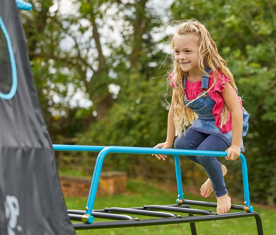 Mädchen klettert auf Kletterturm »Explorer« mit Zelt.