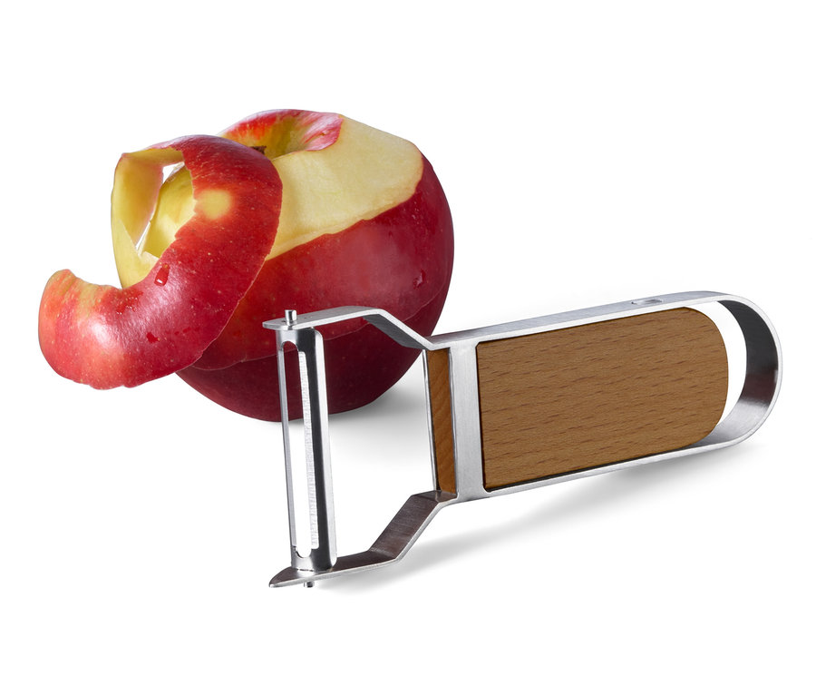 Ein roter Apfel mit Schale neben einem Universalschäler.