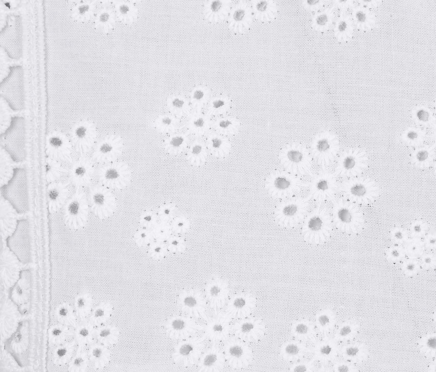 Detailansicht eines weißen Tops mit Stickerei.