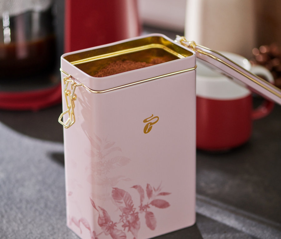 Geöffnete, rosa Kaffeedose mit Kaffee im Inneren.