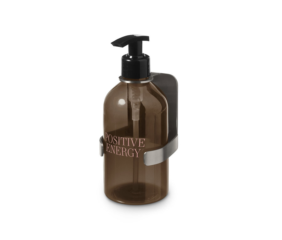 Halter mit Seifenspender mit brauner Flasche mit der Aufschrift Positive Energy.