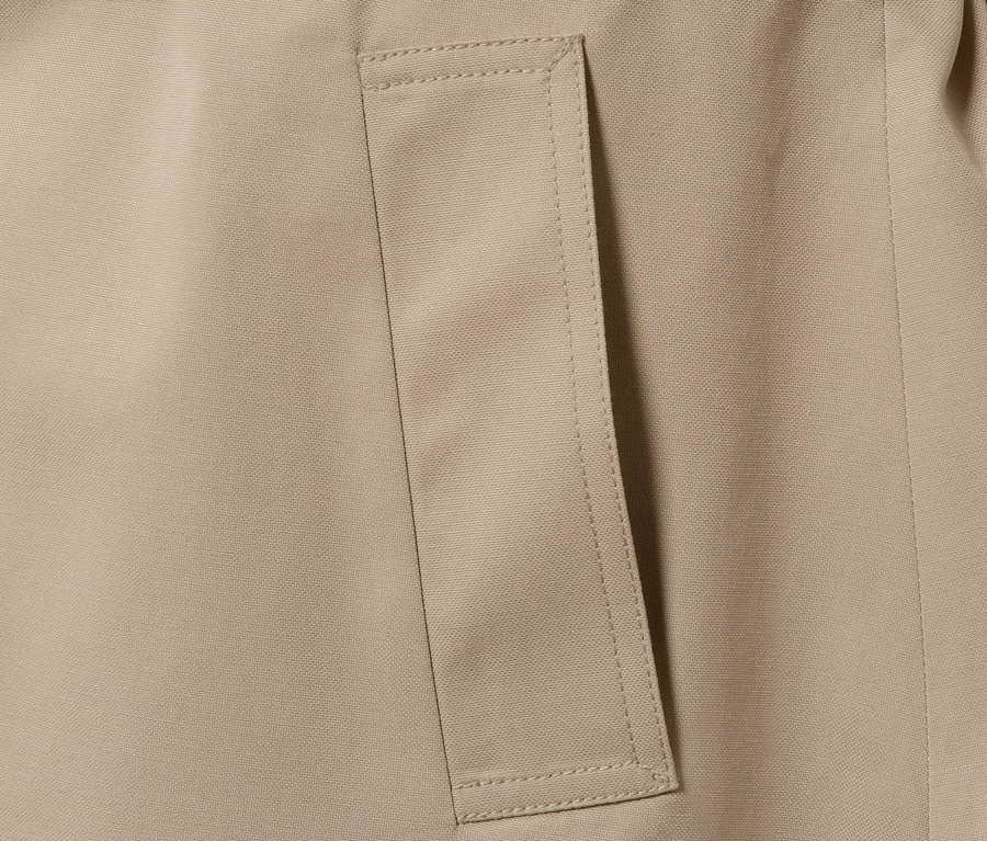 Detailaufnahme eines beigen Trenchcoats mit Tasche.