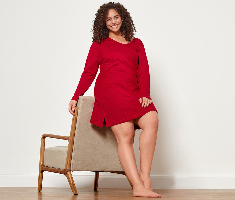 Frau sitzt in einem Ajour-Nachthemd auf einem Stuhl.