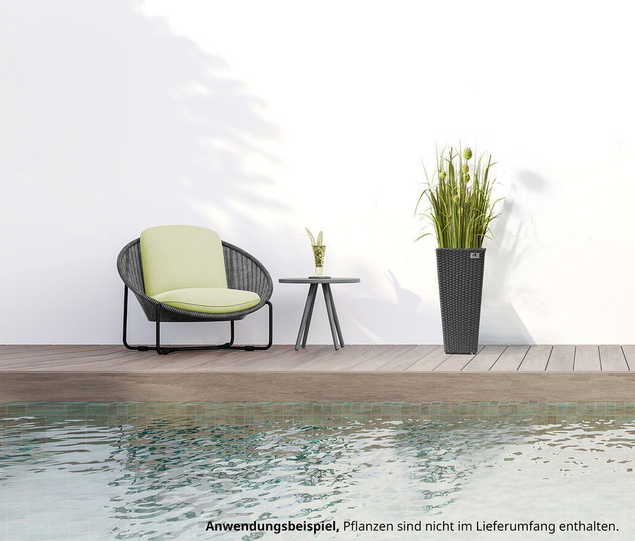Aussenaufnahme mit einer anthrazitfarbenen Polyrattan-Pflanzsäule, Höhe ca. 60 cm, daneben eine Sitzgruppe und ein Tisch, im Hintergrund eine weisse Wand und Grün.