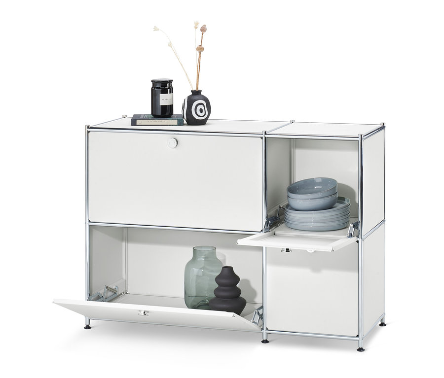 Weißes Sideboard »CN3« mit 4 Klappen. Auf der Oberseite des Schranks befinden sich eine Vase und eine Kerze, im Schrank Teller und Schüsseln.