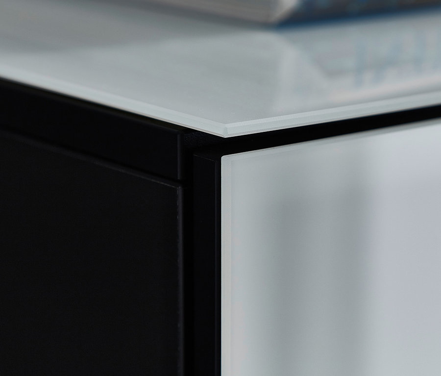 Detailaufnahme der Oberseite eines schwarz-weissen Highboards »Ideeus« mit einem Buch darauf.