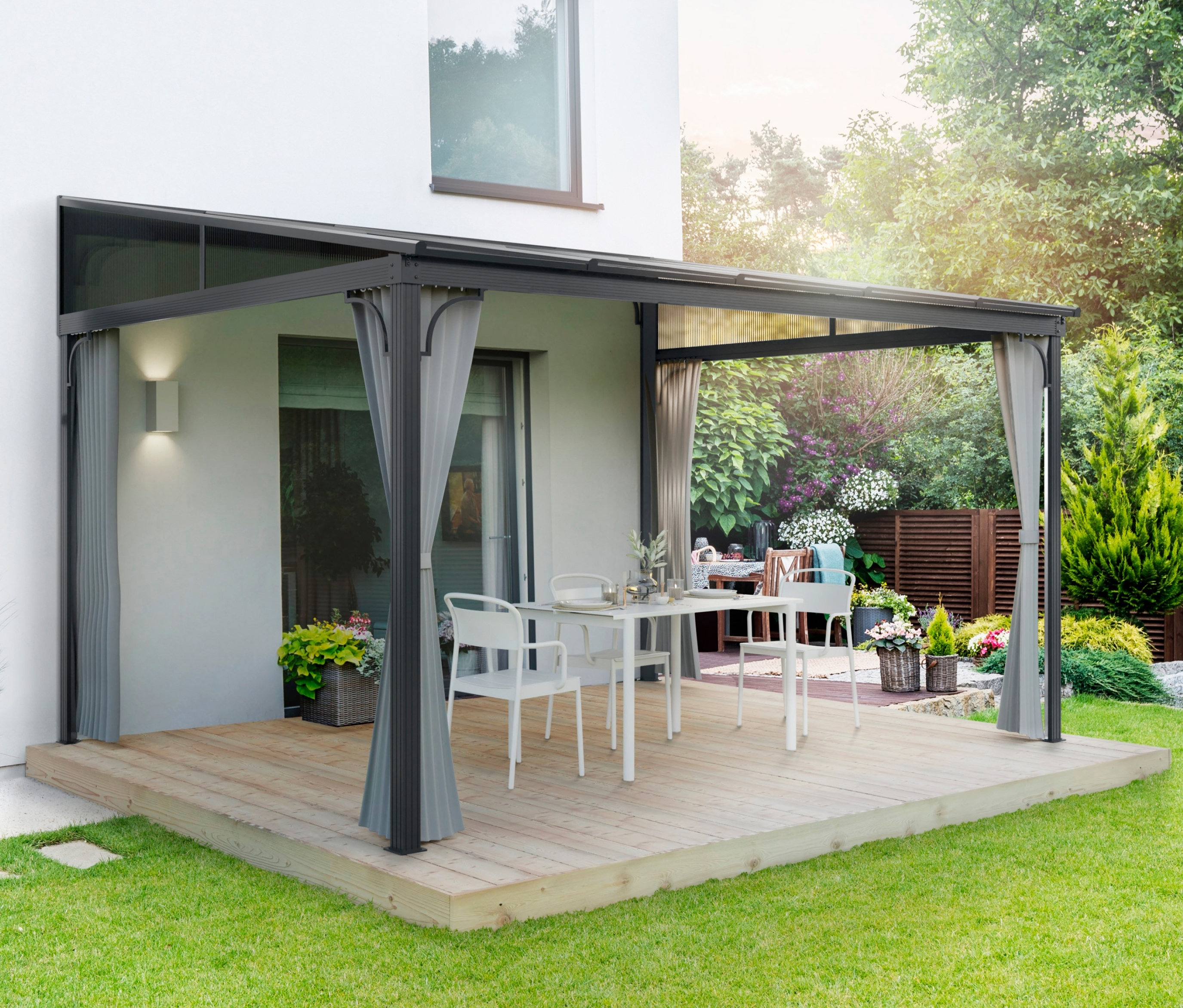 Weiße Stühle und ein Tisch unter einem LECO Terrassendach auf einer Holzterrasse.