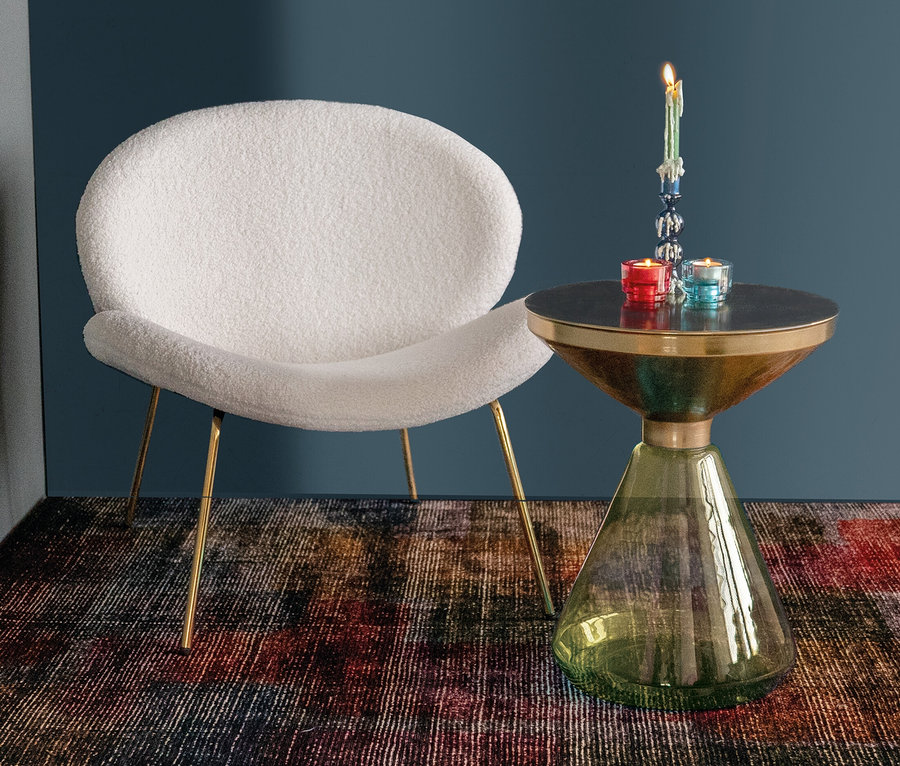 Weißer Sessel und Kayoom Beistelltisch »Roman« mit roter und blauer Kerze auf buntem Teppich.