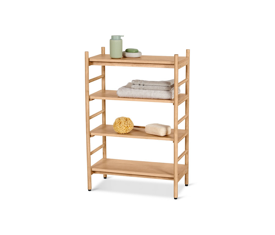 Ein vierstöckiges Sprossenregal mit verstellbaren Böden. In der obersten Ablage befinden sich ein grüner Seifenspender und Seife, in der zweiten Ablage gefaltete Handtücher und in der dritten Ablage ein Badeschwamm und ein Bimsstein.