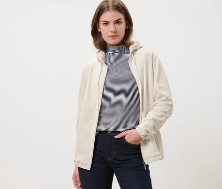 Frau trägt eine cremeweiße Sweatjacke und Jeans.