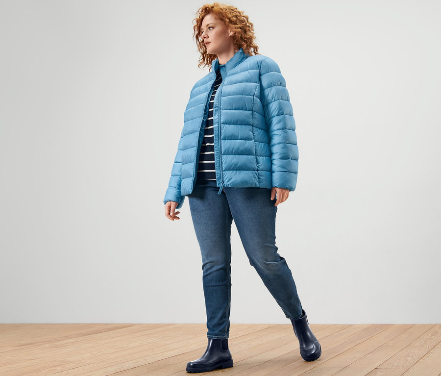 Eine Frau trägt eine Steppjacke, ein gestreiftes Shirt mit 3/4-Arm und Treggings »Fit Nelly«.