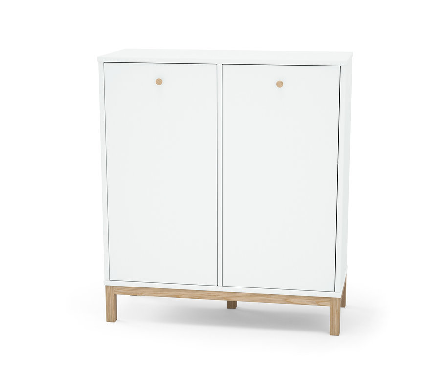 Ein weißes Wäschekorbregal mit zwei Türen mit runden Griffen steht auf Holzfüßen.