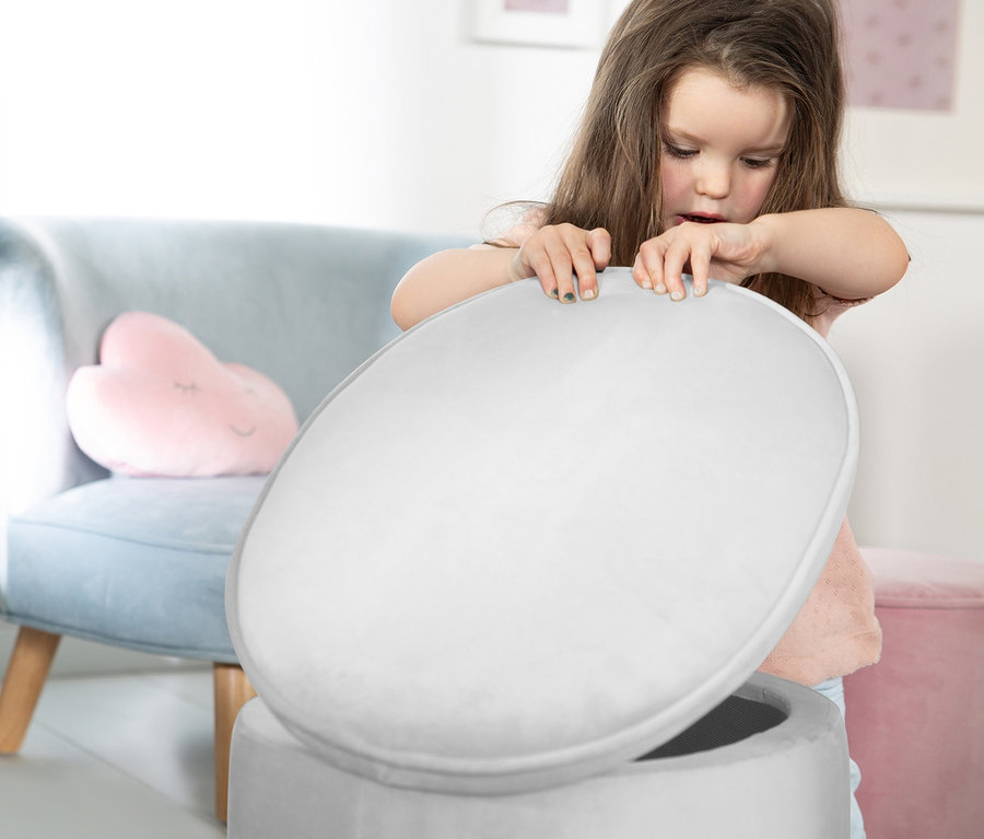 Mädchen öffnet grauen roba Kinderhocker Lil Sofa mit Aufbewahrungsfunktion.